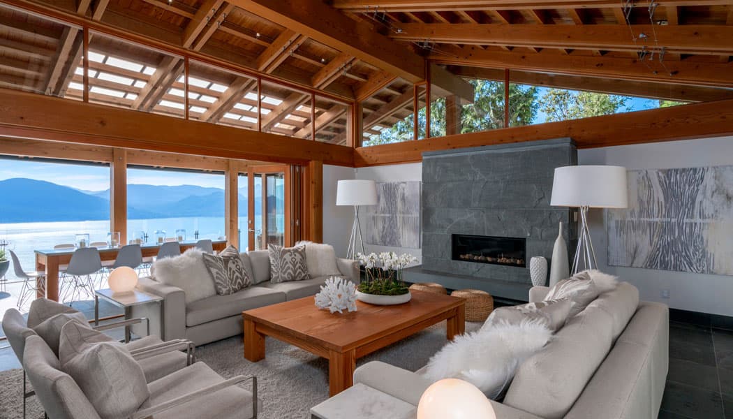 Open-plan living room with timber beams and a view over the water to the mountains